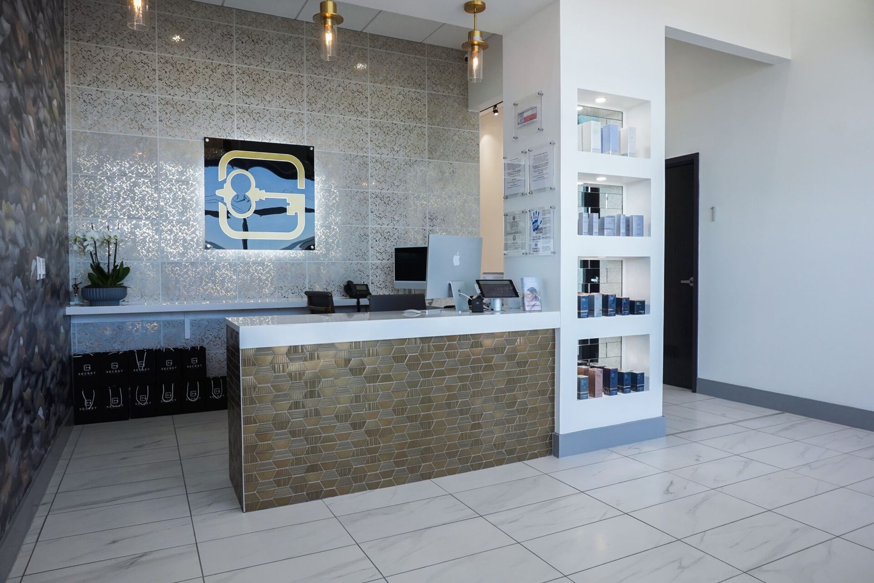 The reception desk and retail wall inside It's A Secret Med Spa, San Antonio